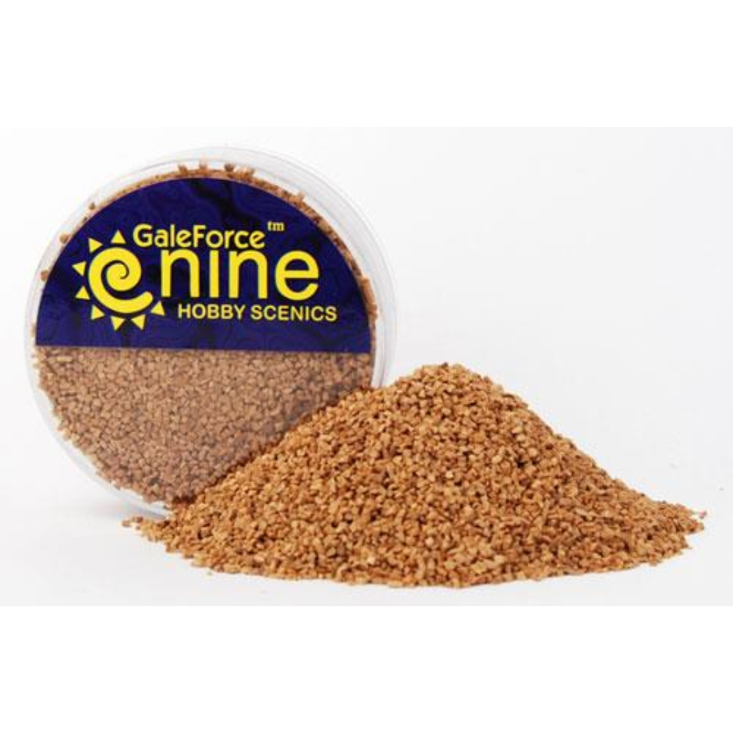 A container of Gale Force Nine Medium Basing Grit (GFS021) showing the coarse organic texture used for realistic miniature gravel and rocky base effects.