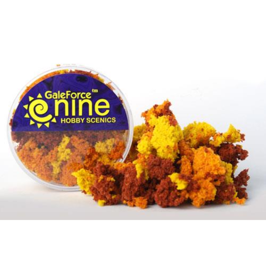 A transparent round container of Gale Force Nine Autumn 3 Color Clump Foliage showing thick, sponge-like clumps of red, orange, and yellow material.