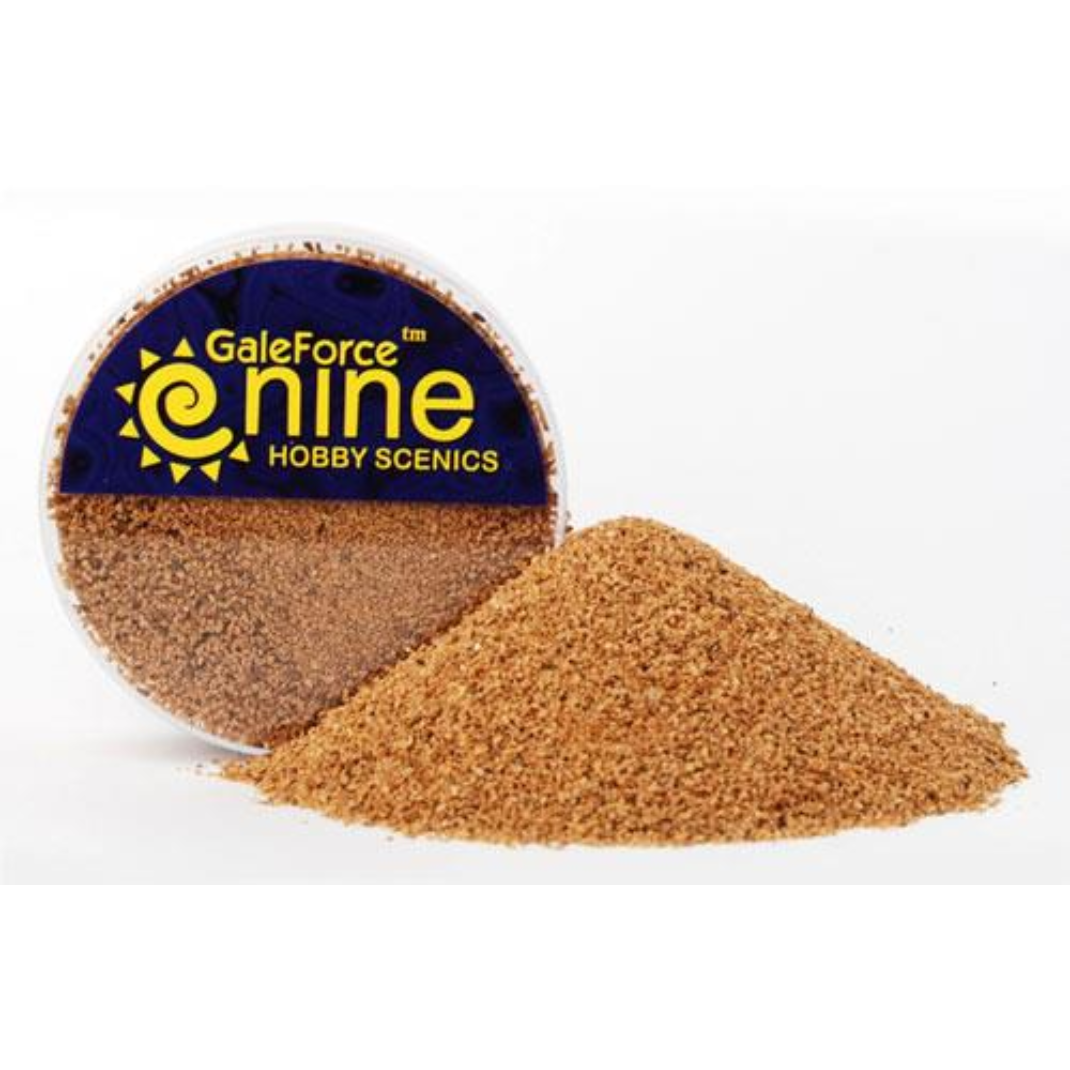 A transparent round container of Gale Force Nine Fine Basing Grit showing the fine, organic texture material used for miniature model bases.